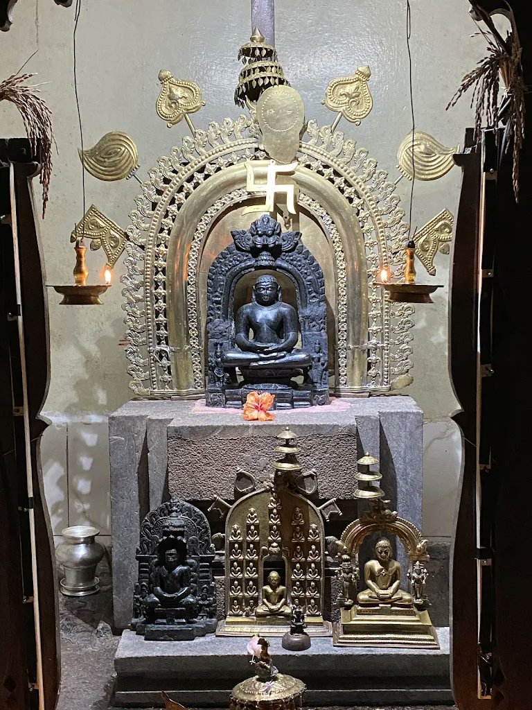 Bronze idol of Anantnath Bhagwan in a sacred Jain shrine with brass lamps